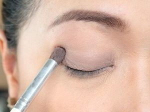 Eye Shadow Primer: Things to Know girl applies eyeshadow primer with a brush on her eye lid