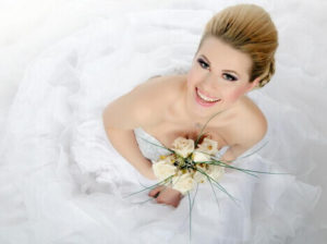 smiling bride with trendy makeup holding flowers