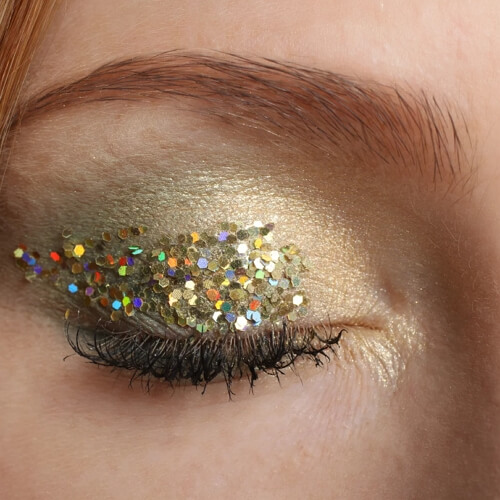 Eye makeup with glitter eyeshadows applied on the upper lid with glue