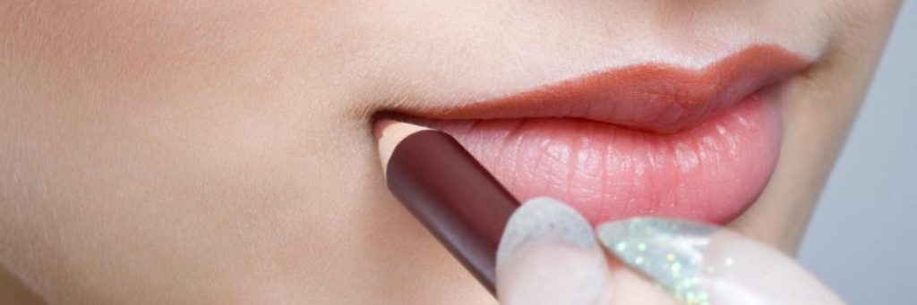 Lady applying lip pencil