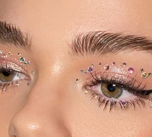 Woman with glitter eyeshadow and rhinestones makeup