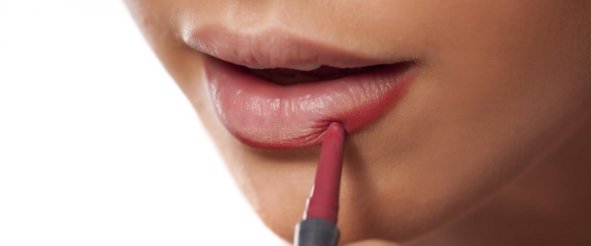 Can I use eyeliner as lip liner? A woman applies nude pink eye liner on dry lips