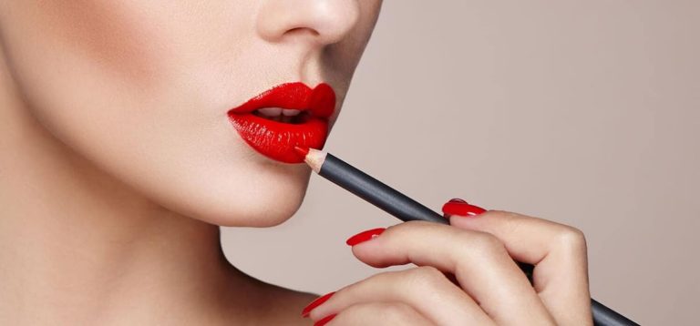A woman applying bright red lip liner
