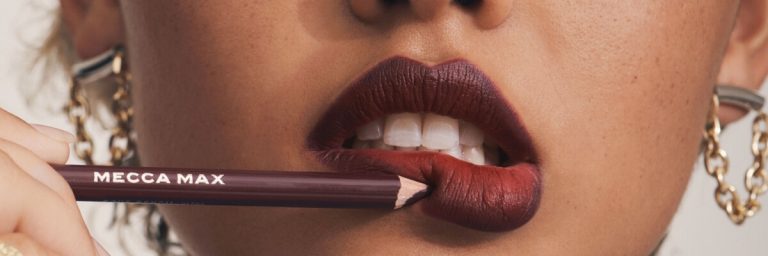Lady applies brown lipstick on her lips