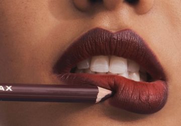 Lady applies brown lipstick on her lips