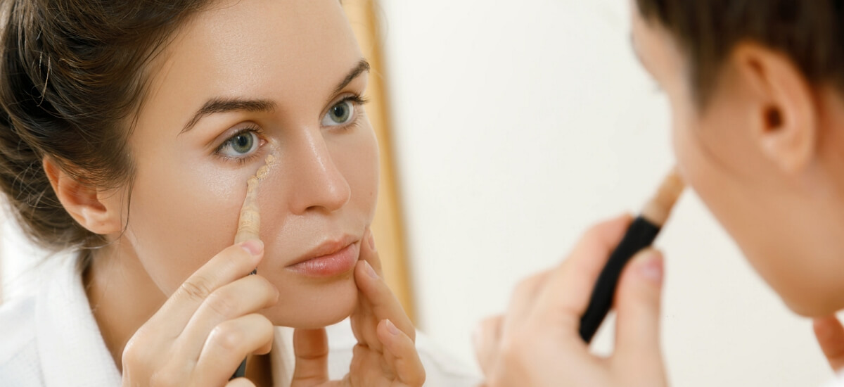 Woman applies transparent water-based eye consealer