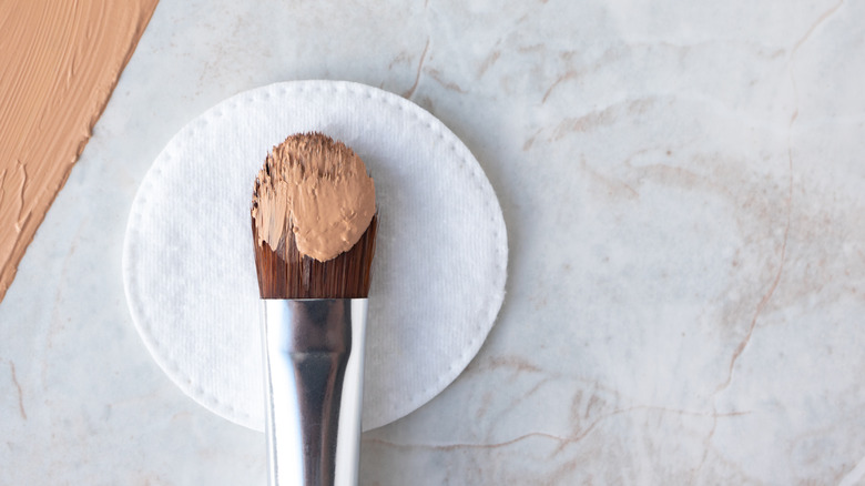 Makeup brush with foundation on its bristles