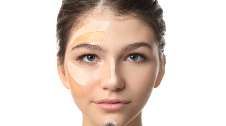 Woman applying different shades of foundation to her face