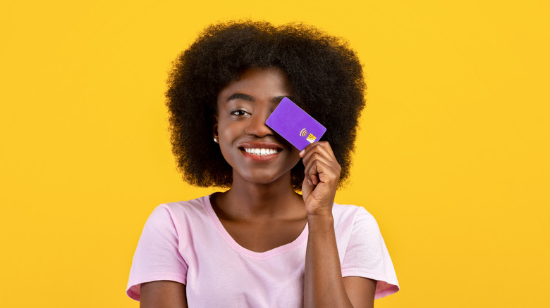 Woman smiles holding credit card