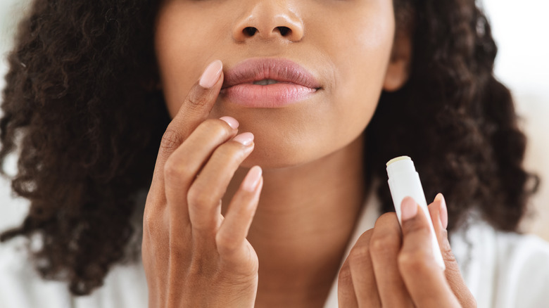 Woman applying a lip moisturizer